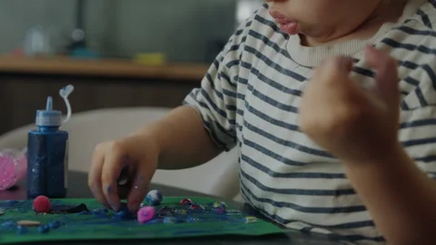 Kid applying glue to the green colored paper to make a greeting card. Closeup Video stock 265132407