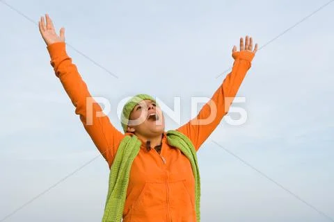 Kid with arms raised singing or faith and praise Stock Photos