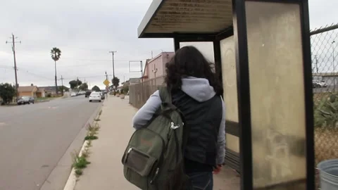 Kid with backpack walks up to bus stop Stock Footage 155488169