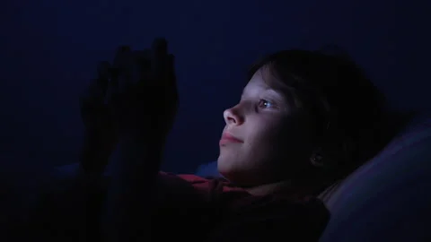 Kid in bed having fun with gadget Stock Footage 171807657