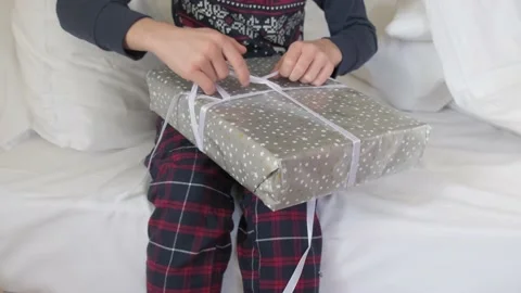 Kid in bed unwrapping gift. Stock Footage 168613668
