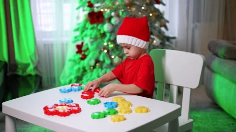 Kid with blocks at Xmas. Young child in a red shirt builds  Video stock 310164756