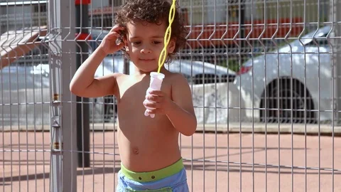 Kid blowing soap bubbles	 Stock Footage 124008775