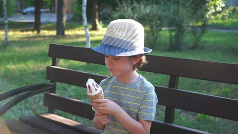 Kid Boy eats Ice cream Cone, licks it with Tongue Video stock 135012005
