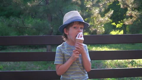 Kid Boy eats Ice cream Cone, licks it with Tongue Video stock 135014157