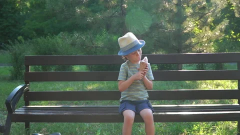 Kid Boy eats Ice cream Cone, licks it with Tongue Video stock 135015368