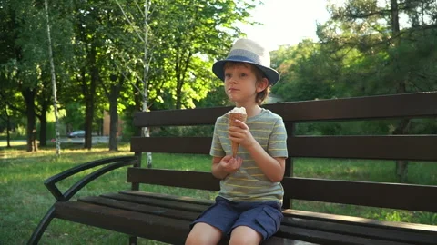 Kid Boy eats Ice cream Cone, licks it with Tongue Video stock 135015782