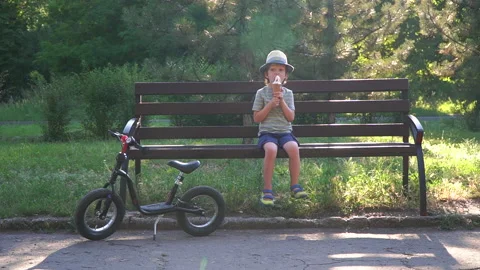 Kid Boy eats Ice cream Cone, licks it with Tongue Video stock 135018020