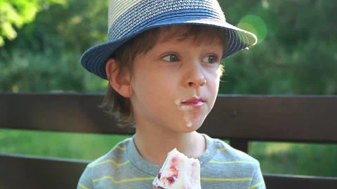 Kid Boy eats Ice cream Cone, licks it with Tongue Video stock 135018407