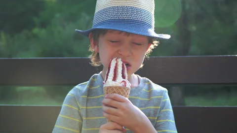 Kid Boy eats Ice cream Cone, licks it with Tongue Video stock 135024208
