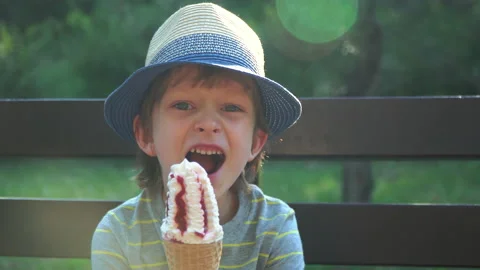 Kid Boy eats Ice cream Cone, licks it with Tongue Video stock 135024455