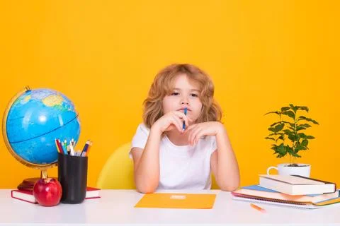 Kid boy from elementary school with book on yellow isolated background. Little Stock Photos