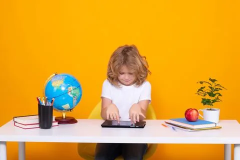 Kid boy from elementary school with book on yellow isolated background. Little Stock Photos