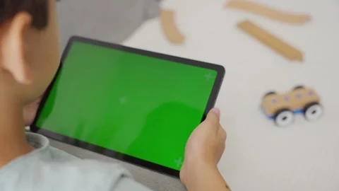 Kid boy gaming or using social media on tablet with chroma key background. Stock Footage 255508839