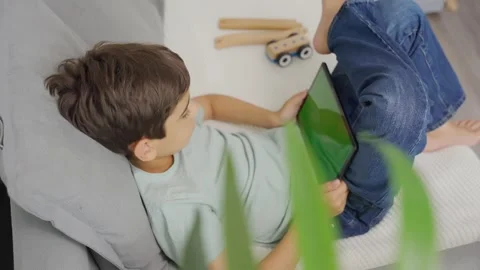 Kid boy gaming or using social media on tablet with chroma key background. Stock-Footage 256617419