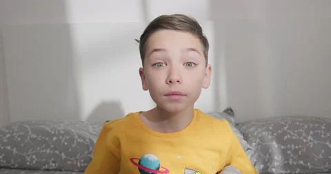 Kid boy gets up from the bed and looks into the camera. Stock-Footage 248191540