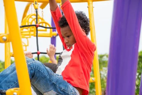Kid boy having fun to play on children's climbing toy at school playground,ba Stock Photos