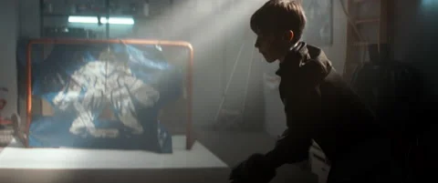 Kid boy hockey player practicing shots inside a covered garage at home Stock Footage 145182908