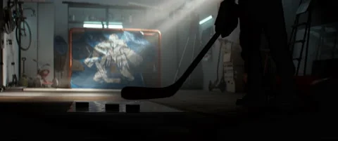 Kid boy hockey player practicing shots inside a covered garage at home Stock Footage 145184053