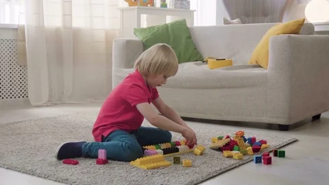 Kid boy imitates engineer constructing a building using colorful meccano Stock Footage 78296903