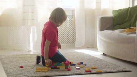 Kid boy imitates engineer constructing a building using colorful meccano Stock Footage 78298842