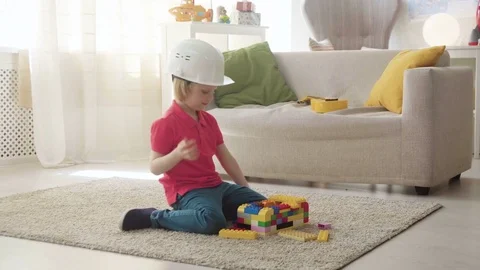 Kid boy imitates engineer constructing a building using colorful meccano Stock Footage 78299730