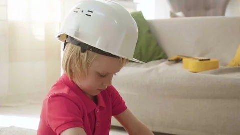 Kid boy imitates engineer constructing a building using colorful meccano Stock Footage 78560596