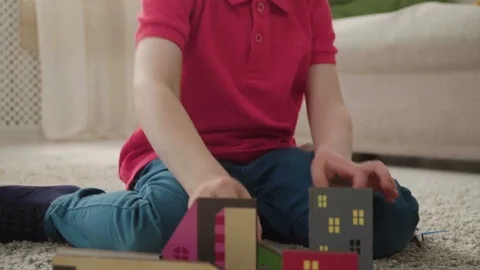 Kid boy imitates engineer constructing a building using colorful meccano Stock Footage 78560645