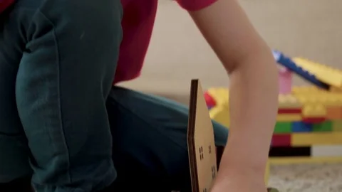 Kid boy imitates engineer constructing a building using colorful meccano Stock Footage 78560807