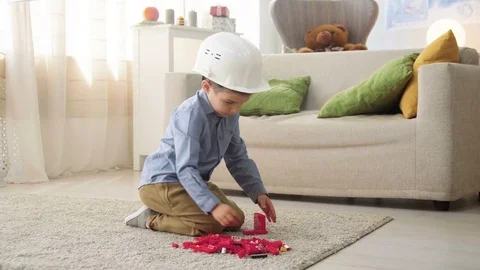 Kid boy imitates engineer constructing a building using colorful meccano Stock Footage 78708494