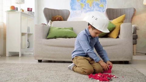 Kid boy imitates engineer constructing a building using colorful meccano Stock Footage 78708613