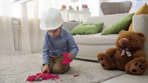 Kid boy imitates engineer constructing a building using colorful meccano Stock Footage 78708732