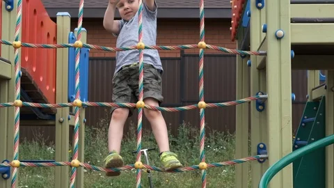 Kid boy playing and climbing on the Playground. Happy child playing in the count Stock Footage 124793183