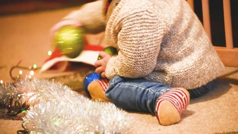 Kid boy playing with Christmas balls, night before Christmas. Stock Footage 166035222