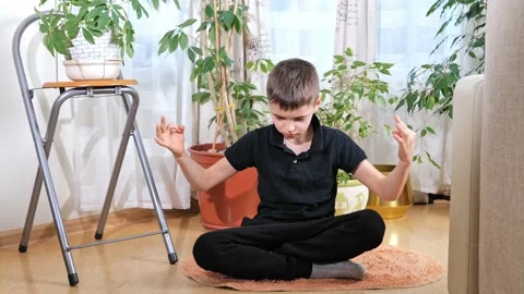 Kid boy practicing yoga, sitting in lotus position, indoor full length. Yogi kid Stock Footage 171565292