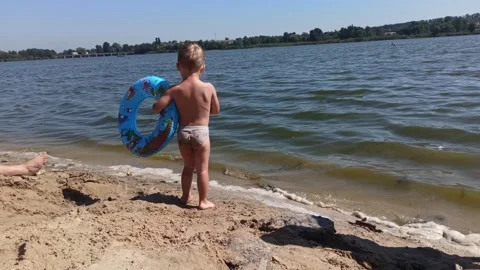 Kid boy  at the river coast watching on the water into distance. Summer leisure Stock Footage 249693989