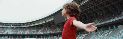 Kid boy spreading hands on a stadium, dreaming of becoming professional player Stock Footage 135171646