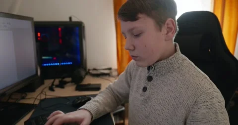 Kid Boy Use Desktop Computer for Study Typing and Reading. 4K 10-bit Stock Footage 336672807