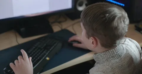 Kid Boy Use Desktop Computer for Study Typing and Reading. 4K 10-bit Stock Footage 337949219