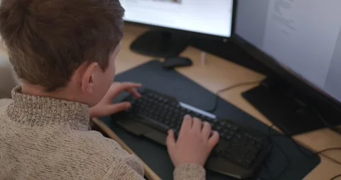 Kid Boy Use Desktop Computer for Study Typing and Reading. 4K 10-bit Stock Footage 337949260