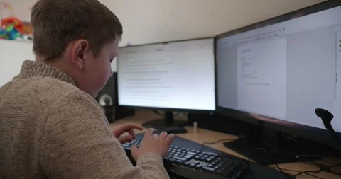 Kid Boy Use Desktop Computer for Study Typing and Reading. 4K 10-bit Stock Footage 339065533