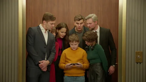 Kid boy is using his smartphone in the elevator, everybody watching the screen Video stock 221623170