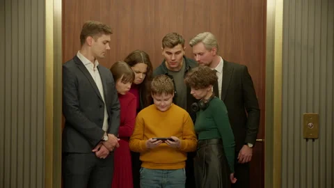 Kid boy is using his smartphone in the elevator, everybody watching the screen 스톡 동영상 221623566