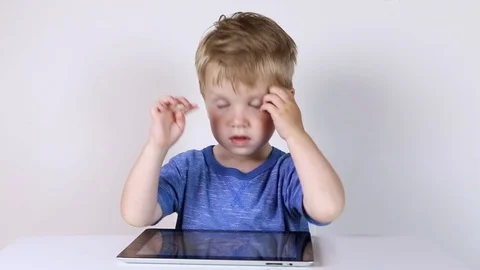 Kid boy using touchscreen tablet technology for playing video Stock Footage 93445372