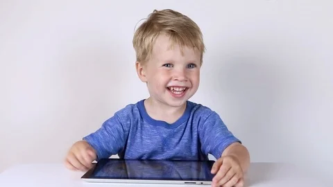 Kid boy using touchscreen tablet technology for playing video Stock Footage 93445675