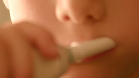 Kid Brushes his theeth with an electric toothbrush Stock Footage 127437010