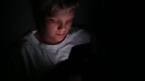 Kid on cell phone in the dark Stock Footage