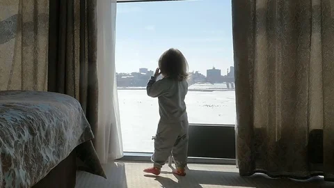The kid, child knocks on the window. Girl looking out the window. Slow motion Stock Footage 76109189