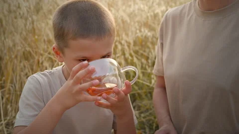 The kid is chilling outside, sipping some tea. Video stock 278985105