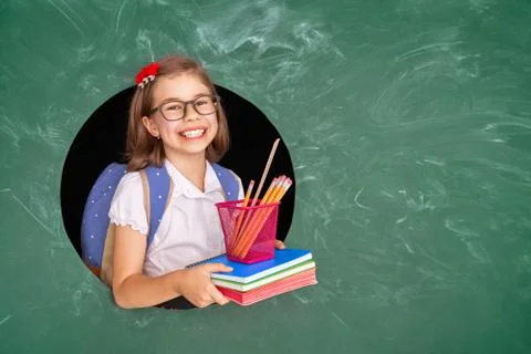 Kid in class on background of blackboard. Stock Photos